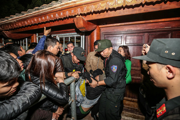 Lực lượng an ninh phải 'giải cứu' người bị ngất xỉu vì chen lấn xin ấn đền Trần - Ảnh: NAM TRẦN